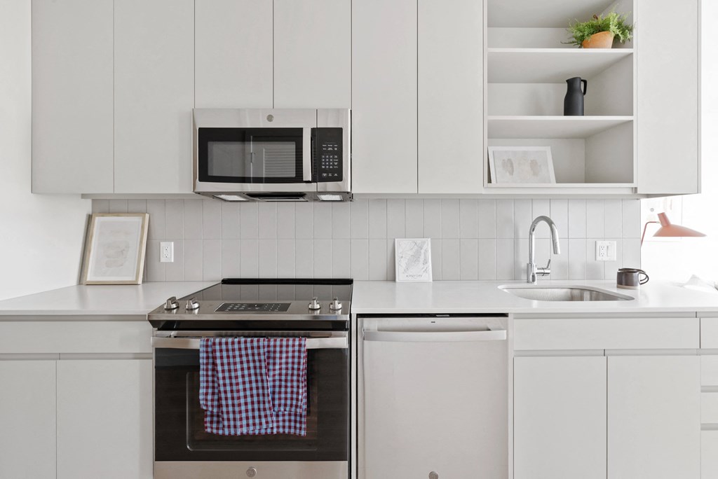 a kitchen with white cabinets and a stove and a microwave