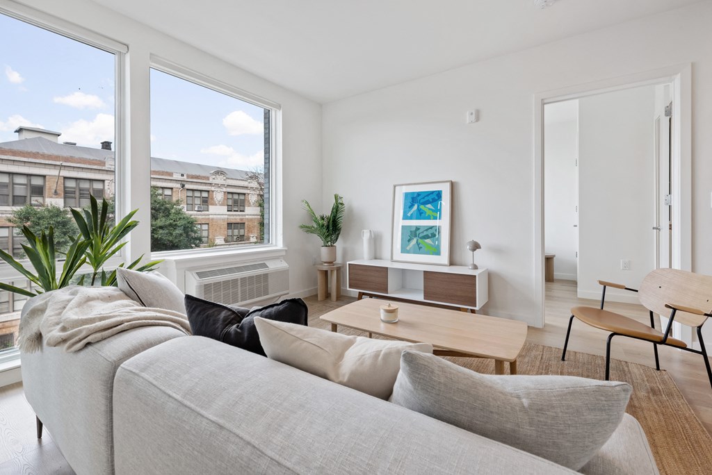 a living room with a couch and a coffee table and large windows