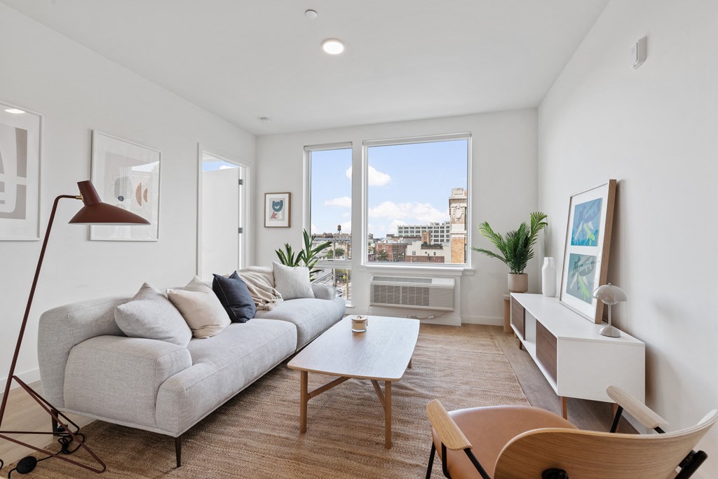 a living room with a gray couch and a large window