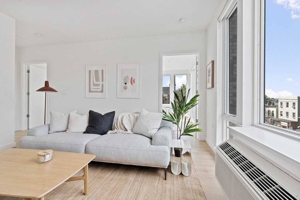 a living room with a gray couch and a large window