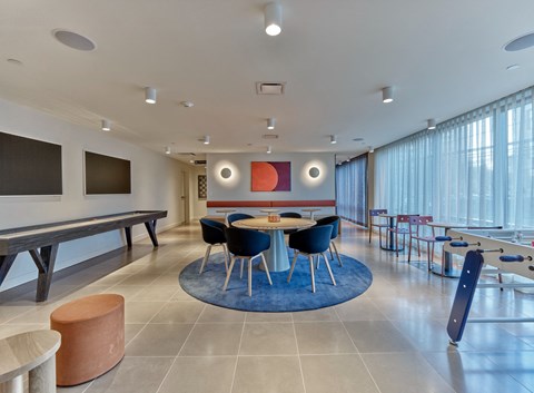 a communal room with tables and chairs and a ping pong table