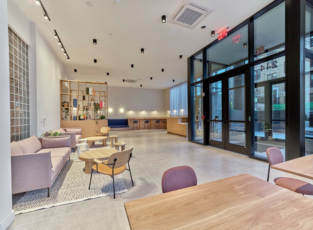 a lobby with couches tables and chairs and glass doors