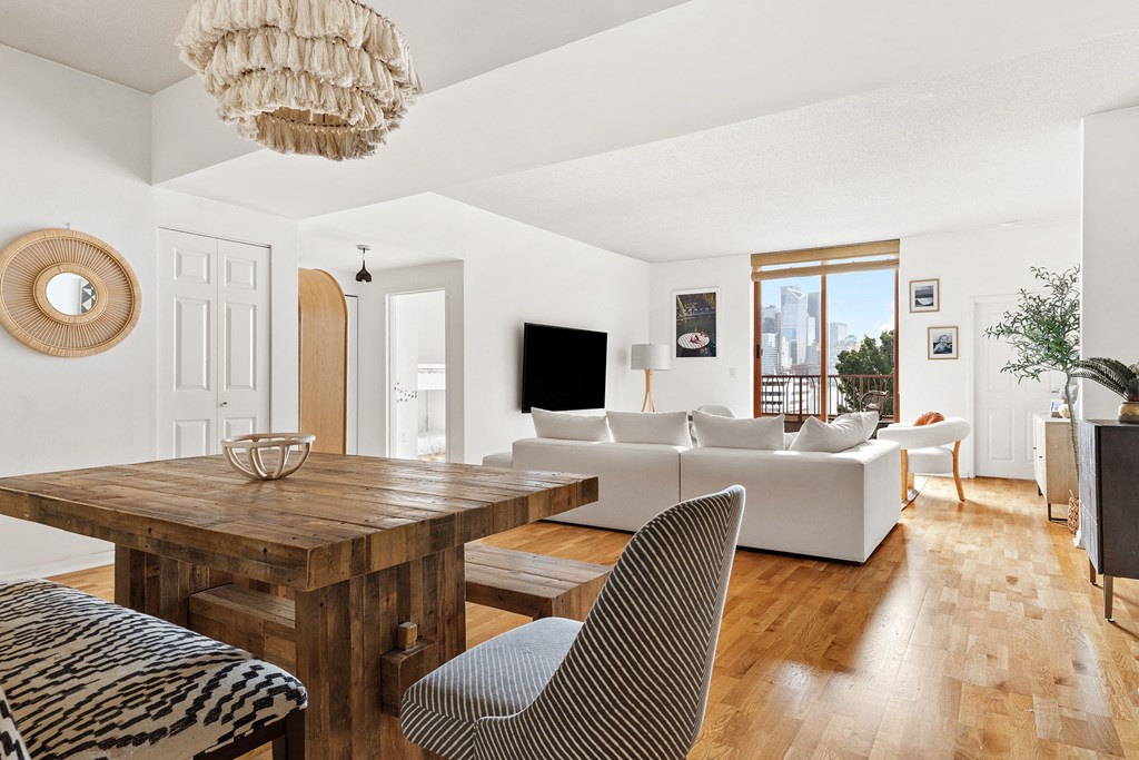 a living room with a wooden dining table and white couches