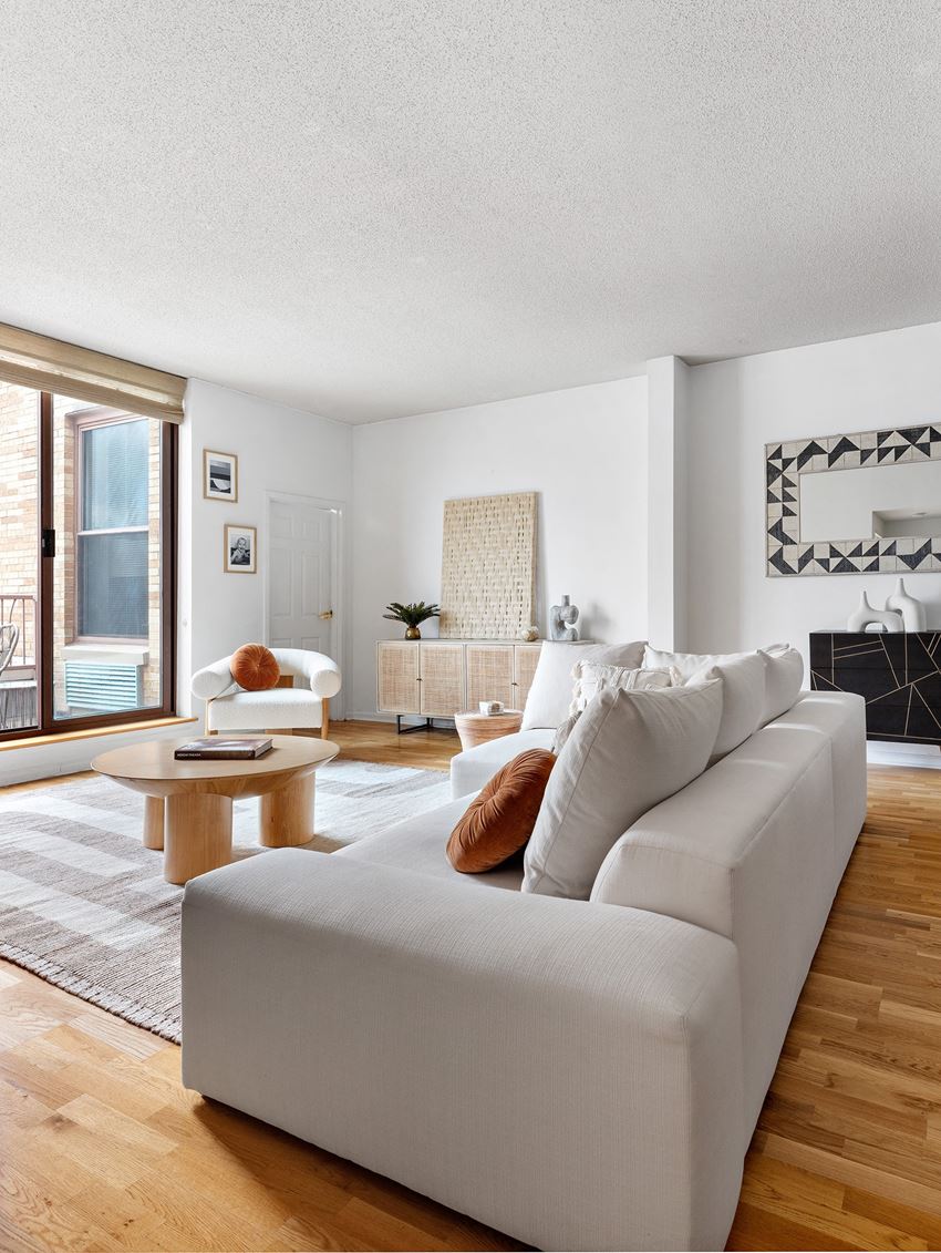 a living room with a white couch and hardwood floors - Photo Gallery