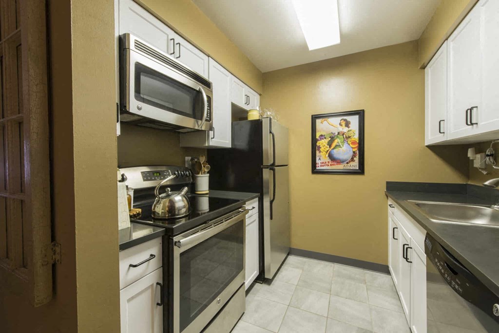 a kitchen with white cabinets and stainless steel appliances
