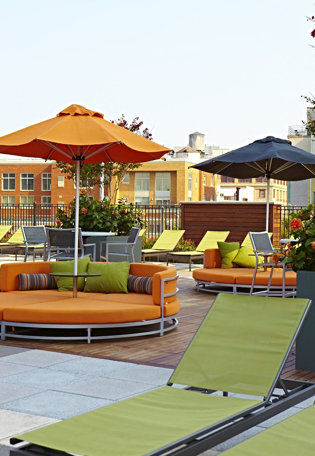 a rooftop lounge area with couches and umbrellas