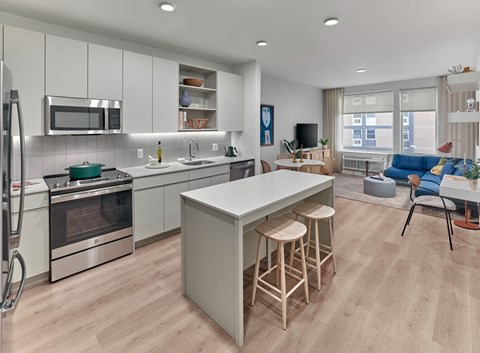 a kitchen and living room with a white counter top