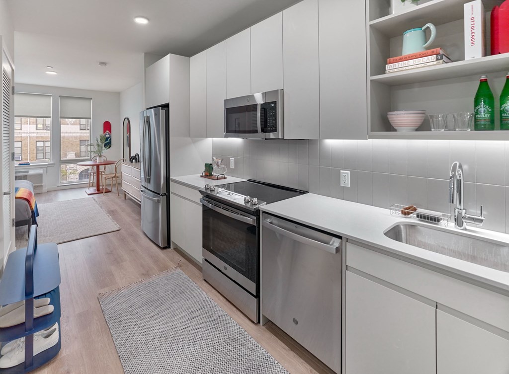 a renovated kitchen with white cabinets and stainless steel appliances