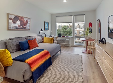 a bedroom with a bed and a desk and a window