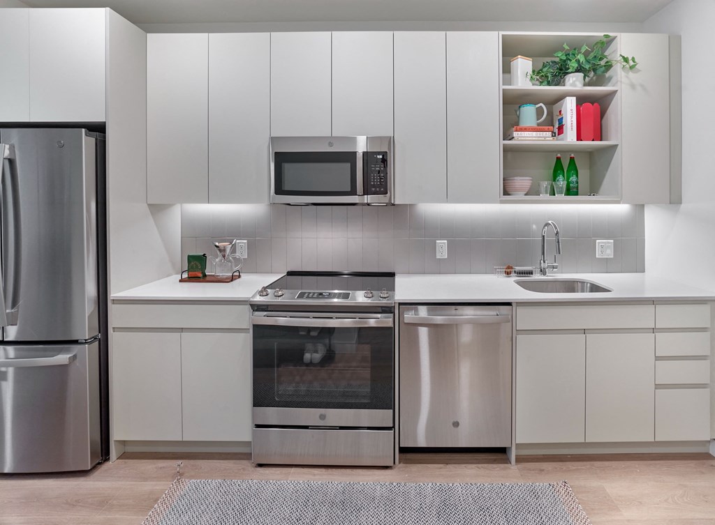 a kitchen with stainless steel appliances and white cabinets