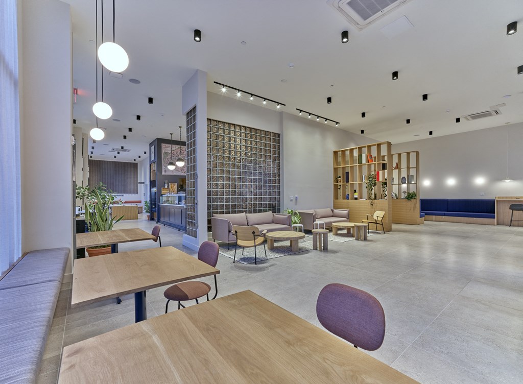 a large lobby with tables and chairs and a library