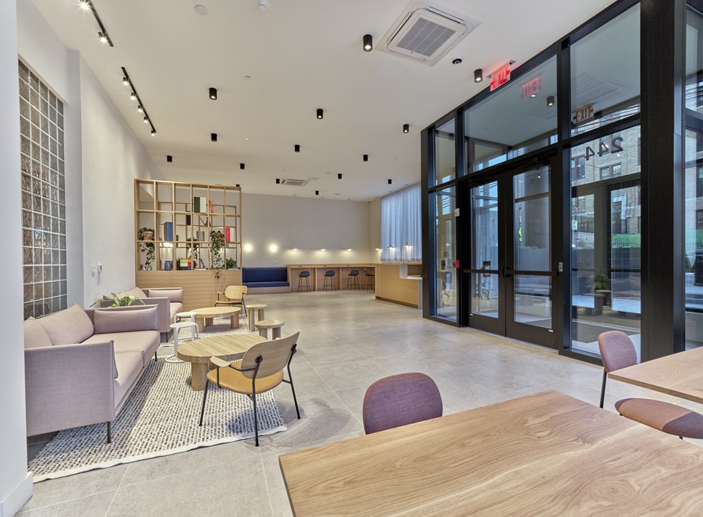 a lobby with couches tables and chairs and glass doors