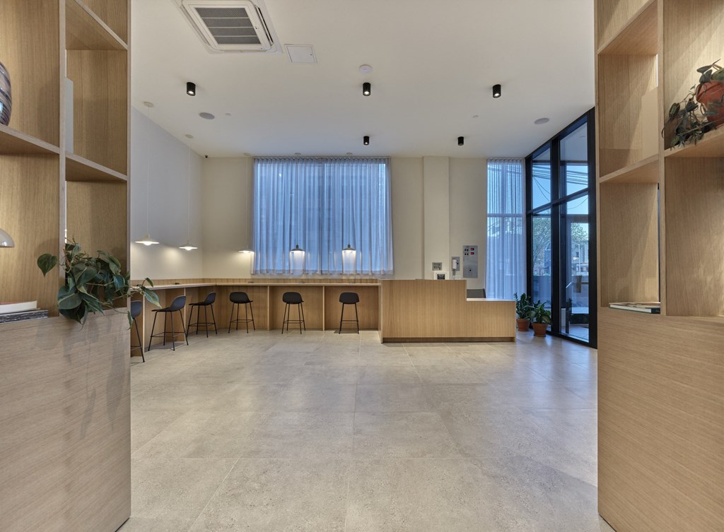 a large room with a counter and chairs and a glass door