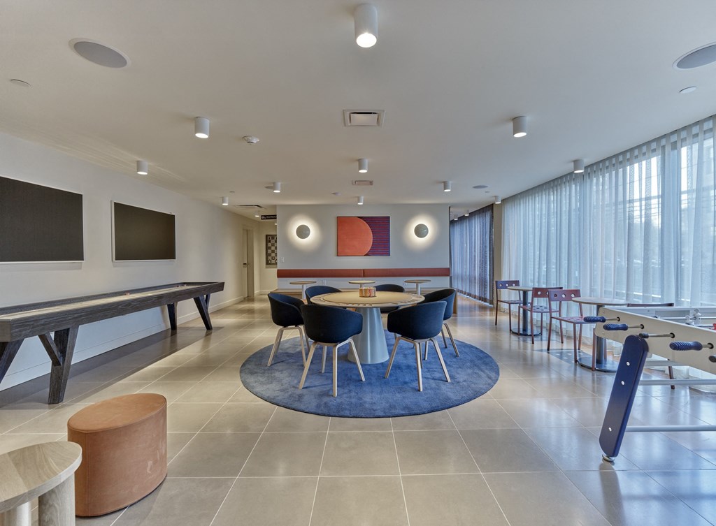 a communal room with tables and chairs and a ping pong table
