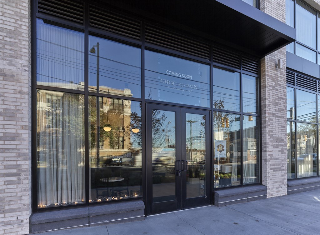 the entrance of a building with glass doors and a brick wall