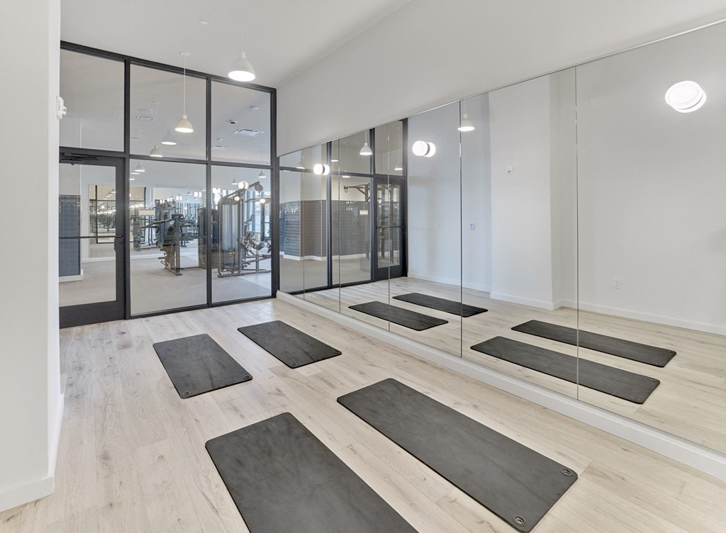 a yoga studio with mirrors and yoga mats on the floor