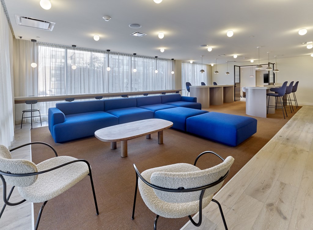 a room with couches tables and chairs and a kitchen