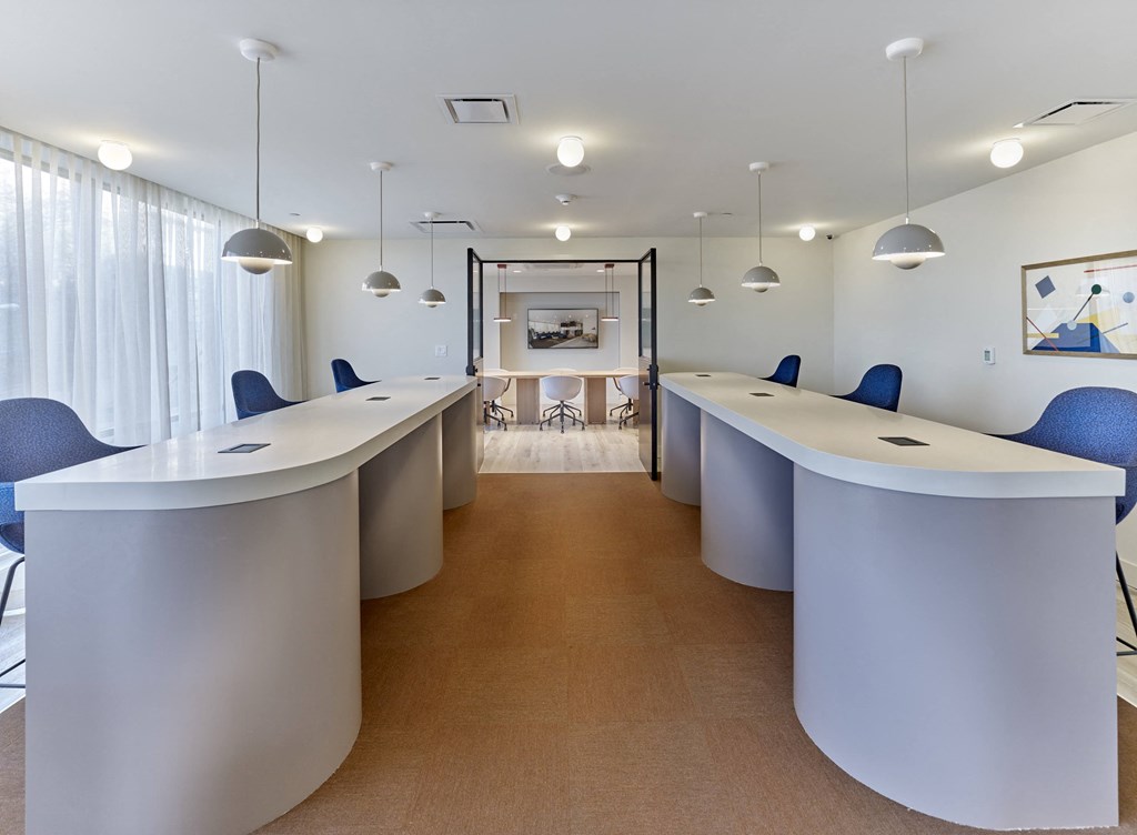 a conference room with blue chairs and white tables