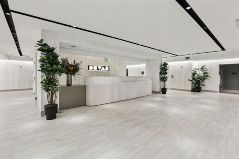 a large lobby with a reception desk and plants
