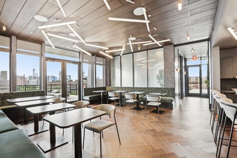 a dining room with tables and chairs and large windows
