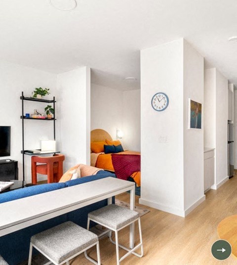 a living room with a couch and a table and a clock