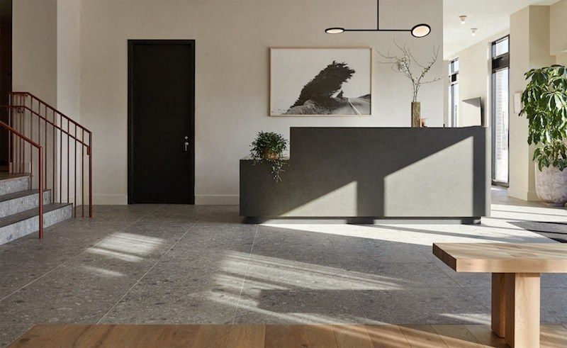 a lobby with a reception desk and a staircase