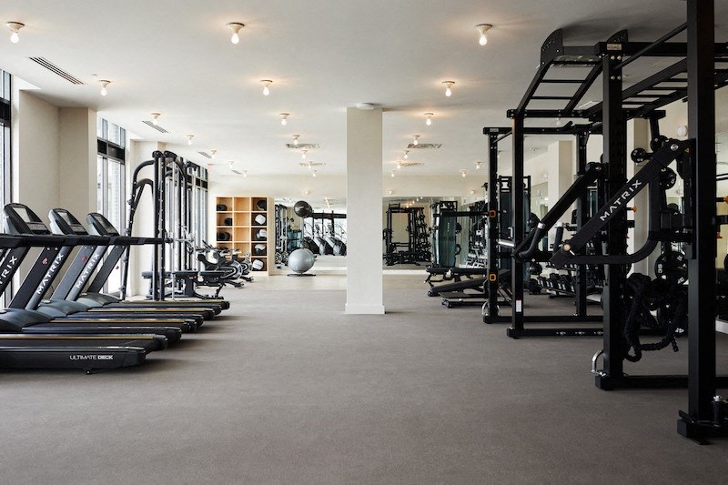 a gym with cardio equipment and weights on the floor