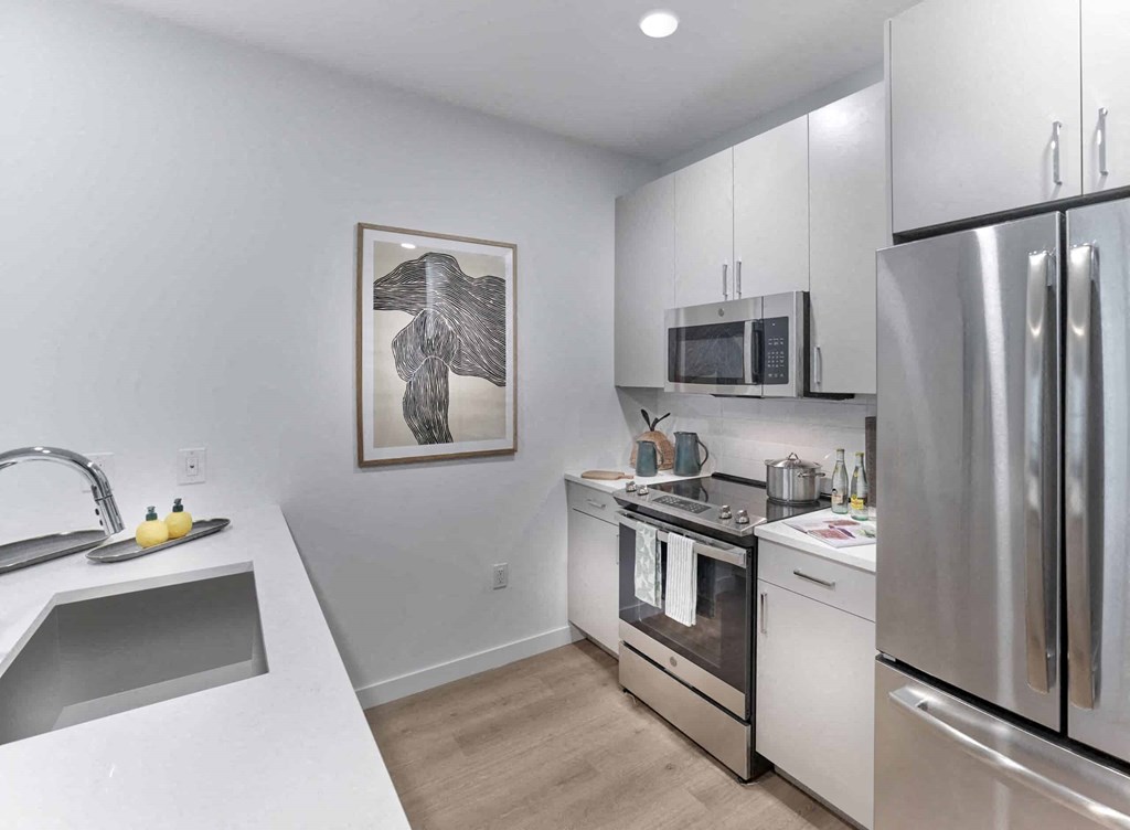 a kitchen with white cabinetry and stainless steel appliances
