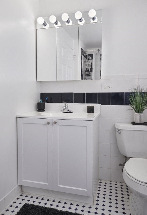 a bathroom with a toilet sink and mirror