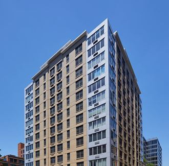 a tall building with many windows and a blue sky in the background