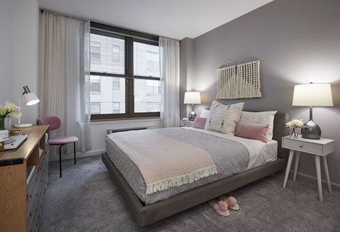 a bedroom with a bed and a desk in a room