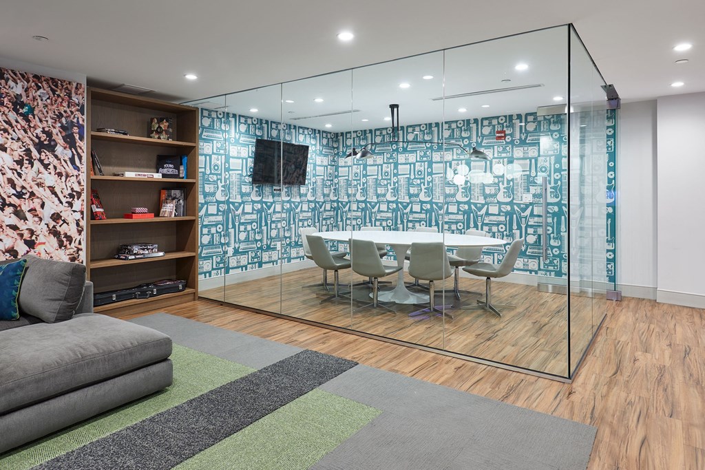 a room with a table and chairs behind a glass wall
