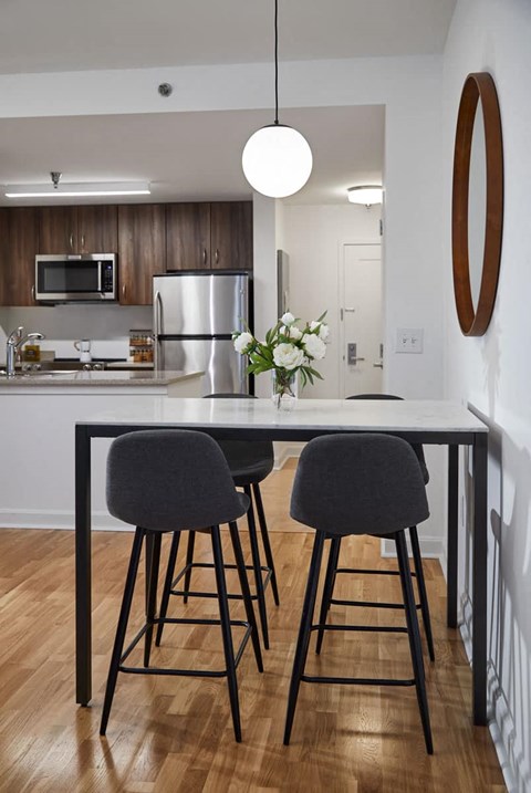A kitchen with a table and two chairs.