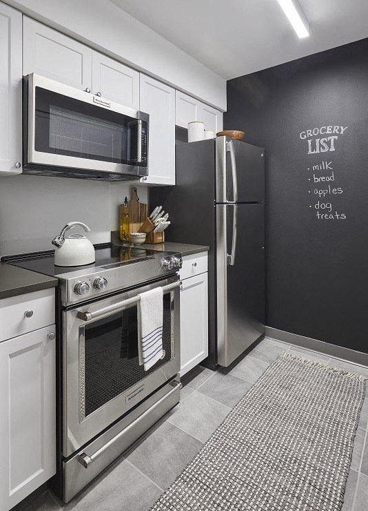 a kitchen with a stove refrigerator and microwave