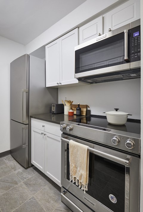 A kitchen with a stainless steel oven and microwave above it.