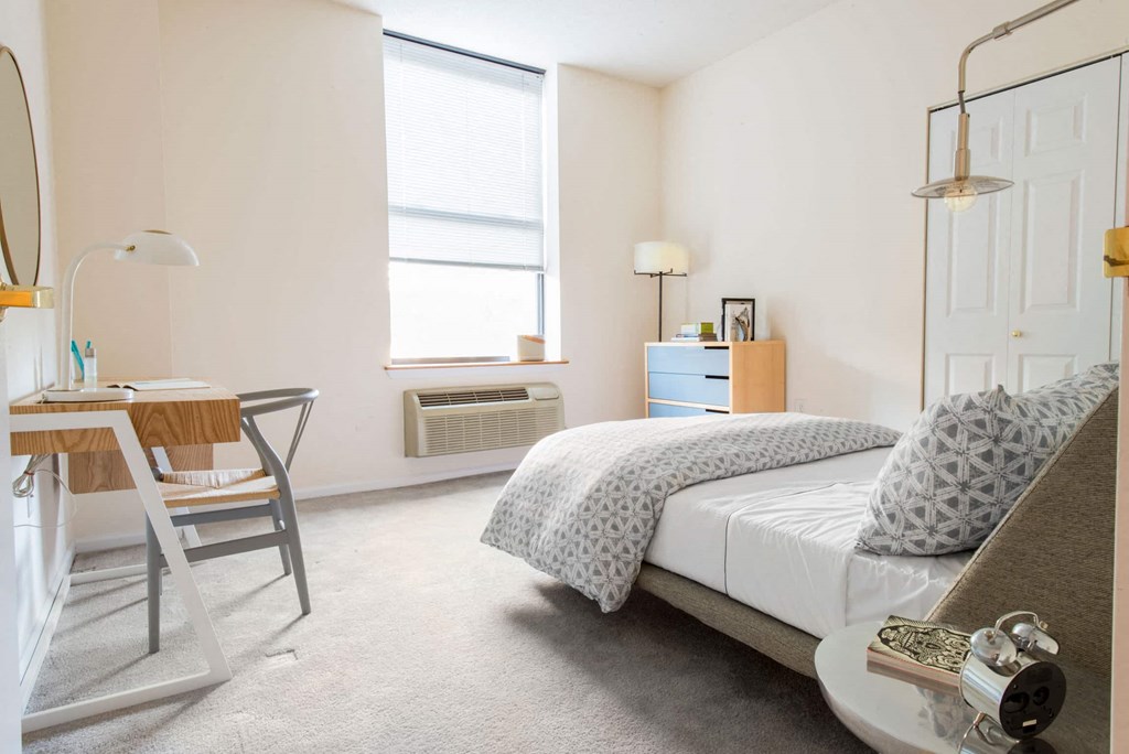 a bedroom with a bed and desk in a 555 waverly unit