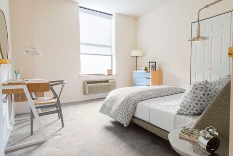 a bedroom with a bed and a desk with a chair