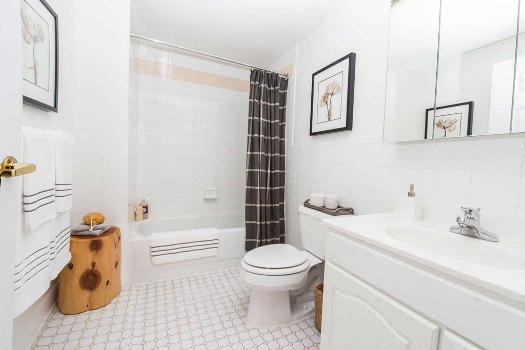 a white bathroom with a black shower curtain
