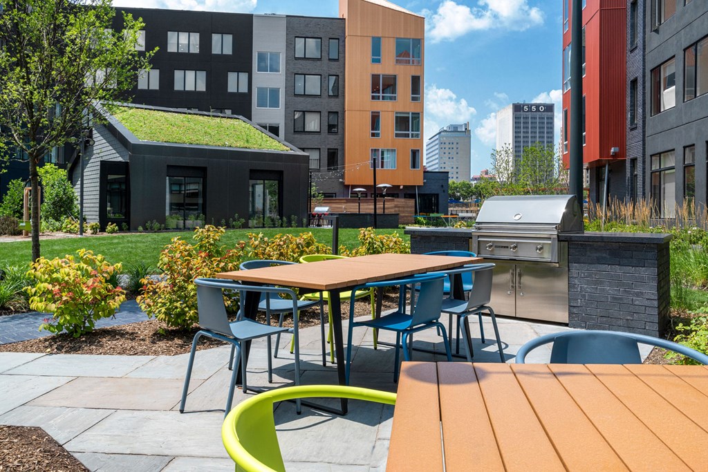 a patio with tables and chairs and a grill