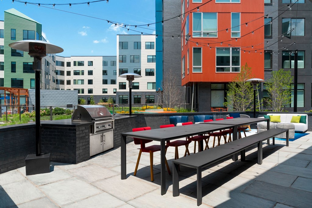 an outdoor patio with a picnic table and barbecue grill