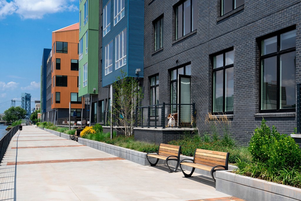 a row of new apartment buildings with benches in front of them
