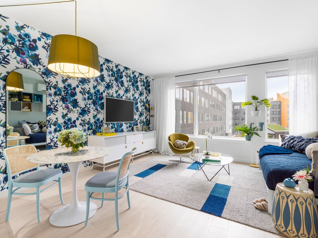 a living room with blue and white floral wallpaper and a blue couch