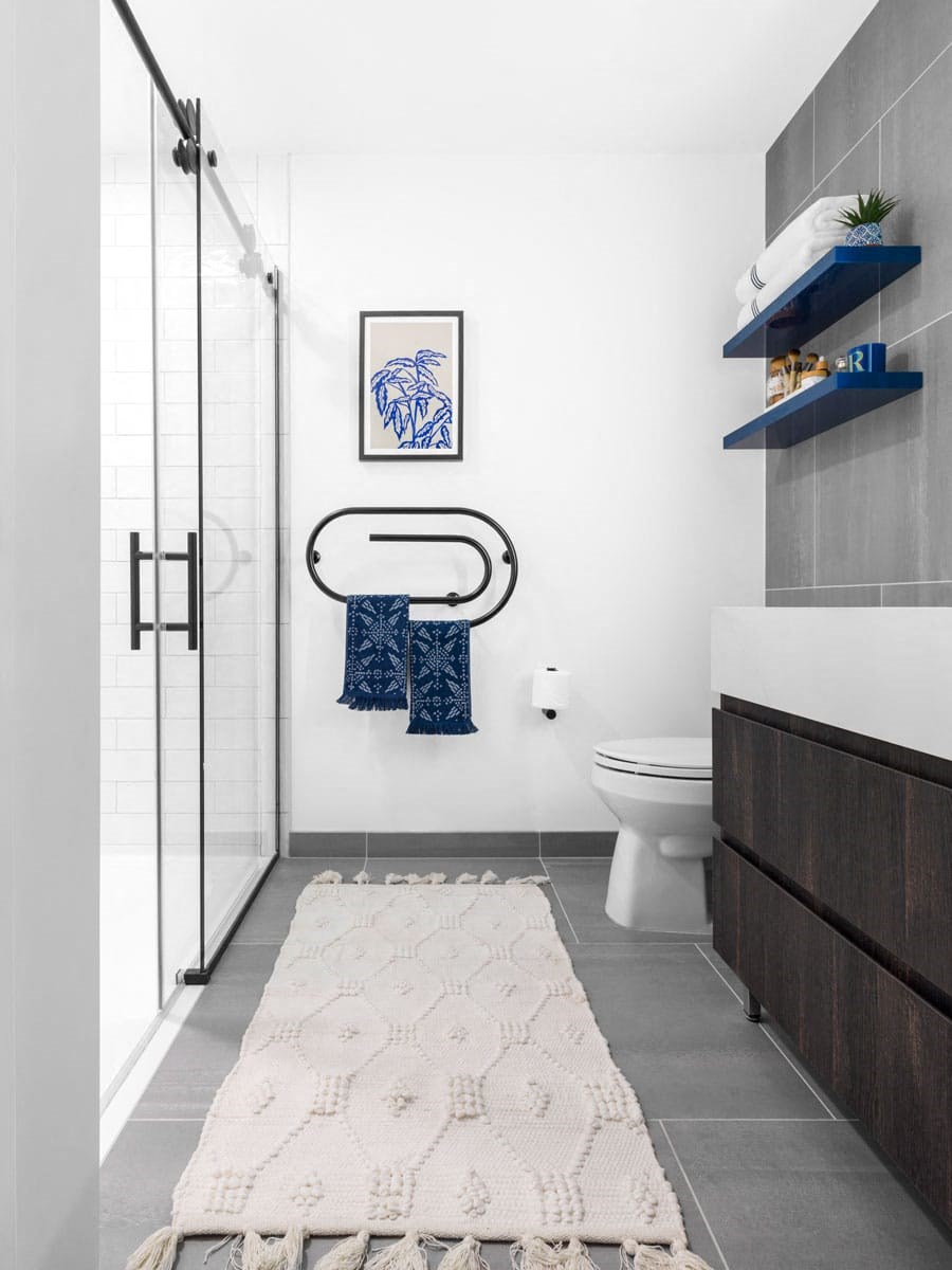 a bathroom with white walls and gray flooring