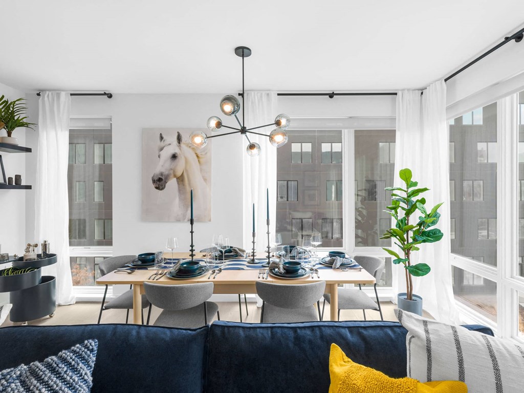 a dining room with a table and chairs and a horse painting on the wall