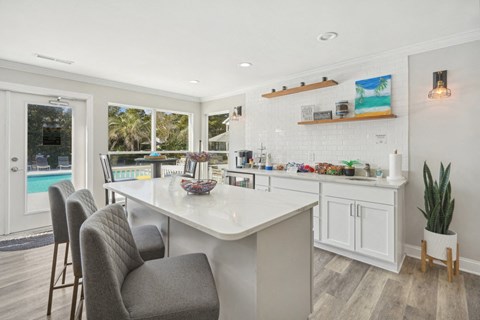 A kitchen with a white countertop and a chair.