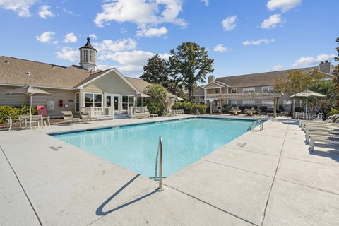 A large swimming pool with a building in the background.