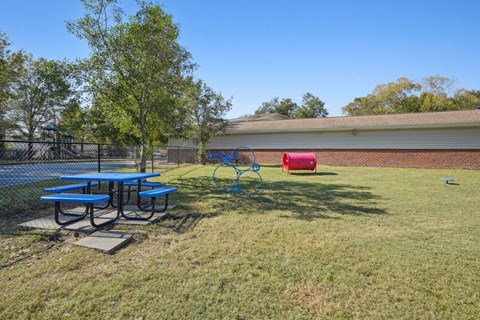 A playground with a blue swing set and a red slide.