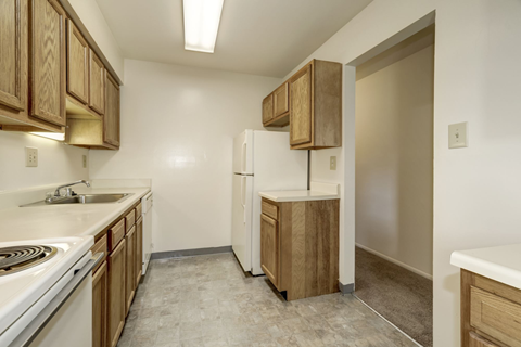 A kitchen with wooden cabinets and a white refrigerator.