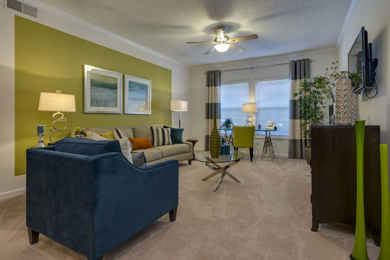 a living room with a blue couch and a ceiling fan