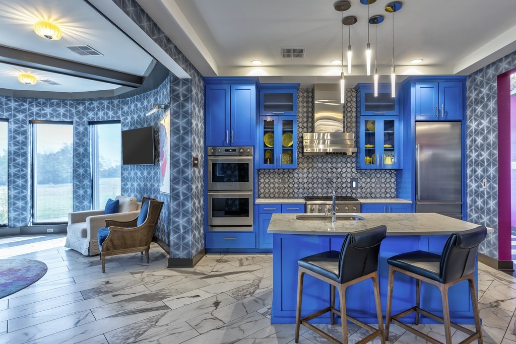 A kitchen with blue cabinets and a marble countertop.
